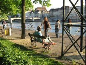 Basel, Unterer Rheinweg, Rheinpromenade, Sitzbank mit
              eingepr�gtem Baslerstab, im Hintergrund die Mittlere
              Br�cke mit der Martinskirche