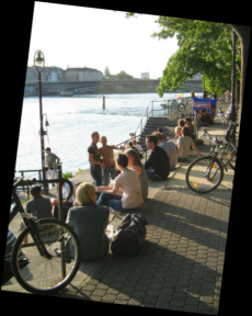 Basel, Unterer Rheinweg,
                                Rheinpromenade, Treppenstufen mit Leuten
                                im Sonnenbad gegenber des Restaurants,
                                im Hintergrund die Johanniterbrcke