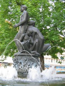 Basel, Zschokkebrunnen, zentrale
                                Figur "Die drei Lebensalter".
                                Erstes Lebensalter: Bub mit Fl�te,
                                sitzend