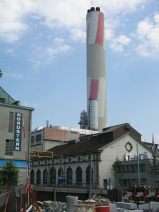 IWB Fernheizkraftwerk Volta 02: Sicht von
                        der Voltastrasse auf den Kamin mit schr�gem
                        Wanderzeichen