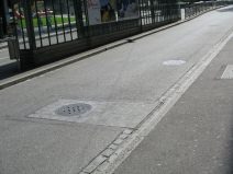 Kanalisationsterror, Stink-Dolendeckel 07
                        an der Tramstation "Heuwaage". Hier
                        sieht man die Stink-Dolendeckel in der Fahrbahn,
                        Nahaufnahme. W�h, das stinkt!