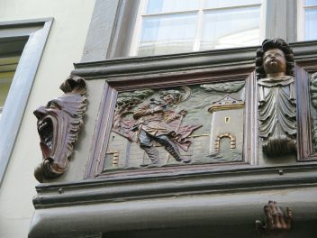 St. Gallen: Kugelgasse 8,
                                    Holzerker, Relief links, ein Mann
                                    steht vor einem Stadttor