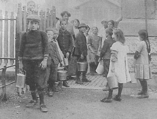 Kinder warten
                im Jahre 1917 in Zrich-Aussersiehl vor dem
                Kern-Schulhaus, wo fr arme Familien eine Suppenkche
                eingerichtet wurde, die die hohen Lebensmittelpreise
                nicht mehr bezahlen konnten [2]