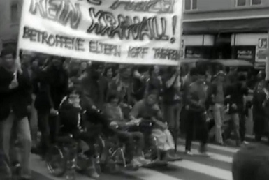Demonstration with
                            the banner "Without police no
                            riot" ("Ohne Polizei kein
                            Krawall") with 3 people in wheel
                            chairs