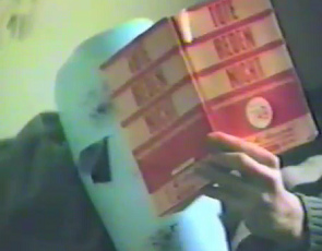 Hausbesetzung an der Badenerstrasse Nr. 2,
                        eine Vogelmaske liest "Reden der
                        Macht"