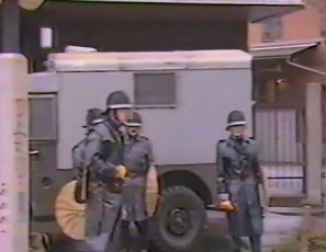 Ein Schl�gerpolizist
                          (Marsmensch) der Stadt Z�rich mit einem
                          Transportwagen f�r Verhaftungen