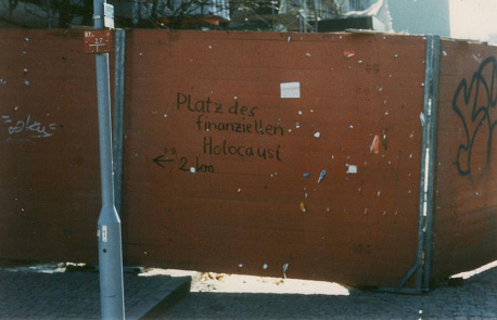Graffiti "Platz des
              finanziellen Holocaust 2 km" mit Wegweiser in
              Richtung Paradeplatz, wo damals die SBG und die CS ihren
              Hauptsitz hatten, Foto von 1997