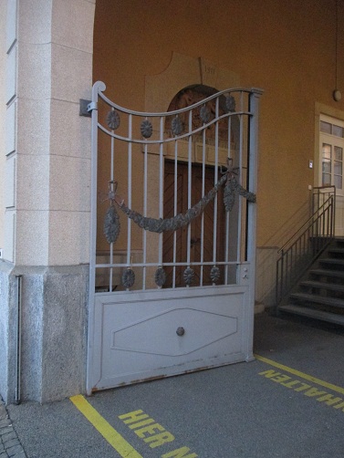 Langenthal, die
                        Weinhandldung Grossenbacher, die B�ndnisgirlande
                        am Eingangstor und unten eine Sonnenhieroglyphe
                        im variierten Rechteck