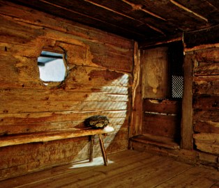 Klause, Innenraum mit
                              Gitterfensterchen zur Kapelle