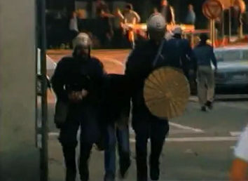 Two Zurich bully
                            policemen (Nazis in blue) are turning the
                            arms of an unarmed woman at the crossing of
                            Custom Street / Wheel Lane (Zollstrasse /
                            Radgasse), evening of Sep. 4, 1980. The
                            woman screams for help