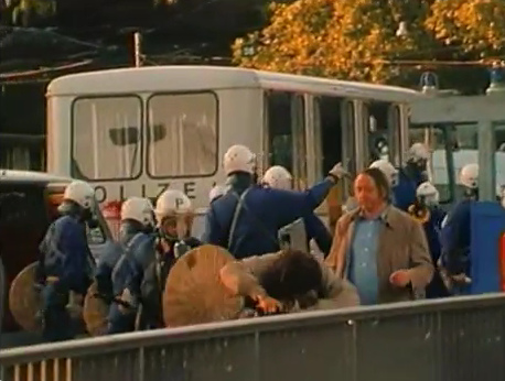 The woman who is
                            hit by the criminal bully policeman of
                            Zurich is protecting her face with both
                            hands on the railing, Station Quay in
                            Zurich, evening of Sep. 4, 1980