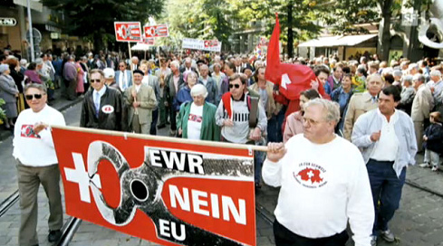 Ein Plakat der SVP mit der Behauptung,
                          dass das Schweizer Kreuz in die Zange genommen
                          werde, zuerst der EWR, dann die EU